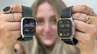 Девушка держит двое Apple Watch: на одних таймер стирки, на других кольца активности