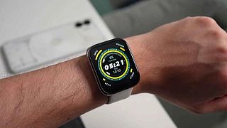 Квадратные часы на светлом ремешке: 05:21, пульс 65 и 1010 шагов на экране