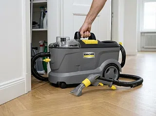 Karcher Puzzi 10/1 в прихожей: рука берётся за ручку, машина ростом до колена рядом с дверным проёмом