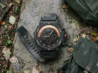 Смарт-часы CGWatch Force 2 на мокром камне лесной тропы, безель с метками GPS и SPORT