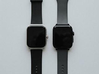 CGWatch Nova с AMOLED и CGWatch Sport с IPS лежат рядом на сером столе, оба экрана погашены