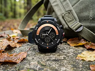Смарт-часы CaseGuru CGWatch Force 2 в милитари-корпусе лежат на камне у рюкзака в осеннем лесу
