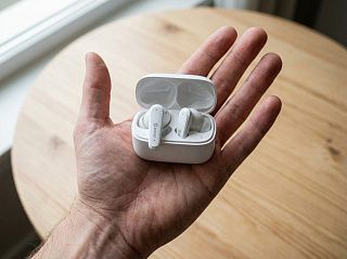 Наушники CaseGuru CGPods Air Pro с открытым кейсом на ладони для сравнения размера