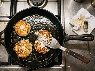 Сырники на сковороде в кипящем масле, один порвался пополам при подъёме лопаткой
