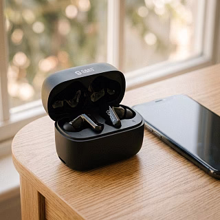 Наушники CGPods Air Pro в открытом кейсе на рабочем столе рядом с телефоном